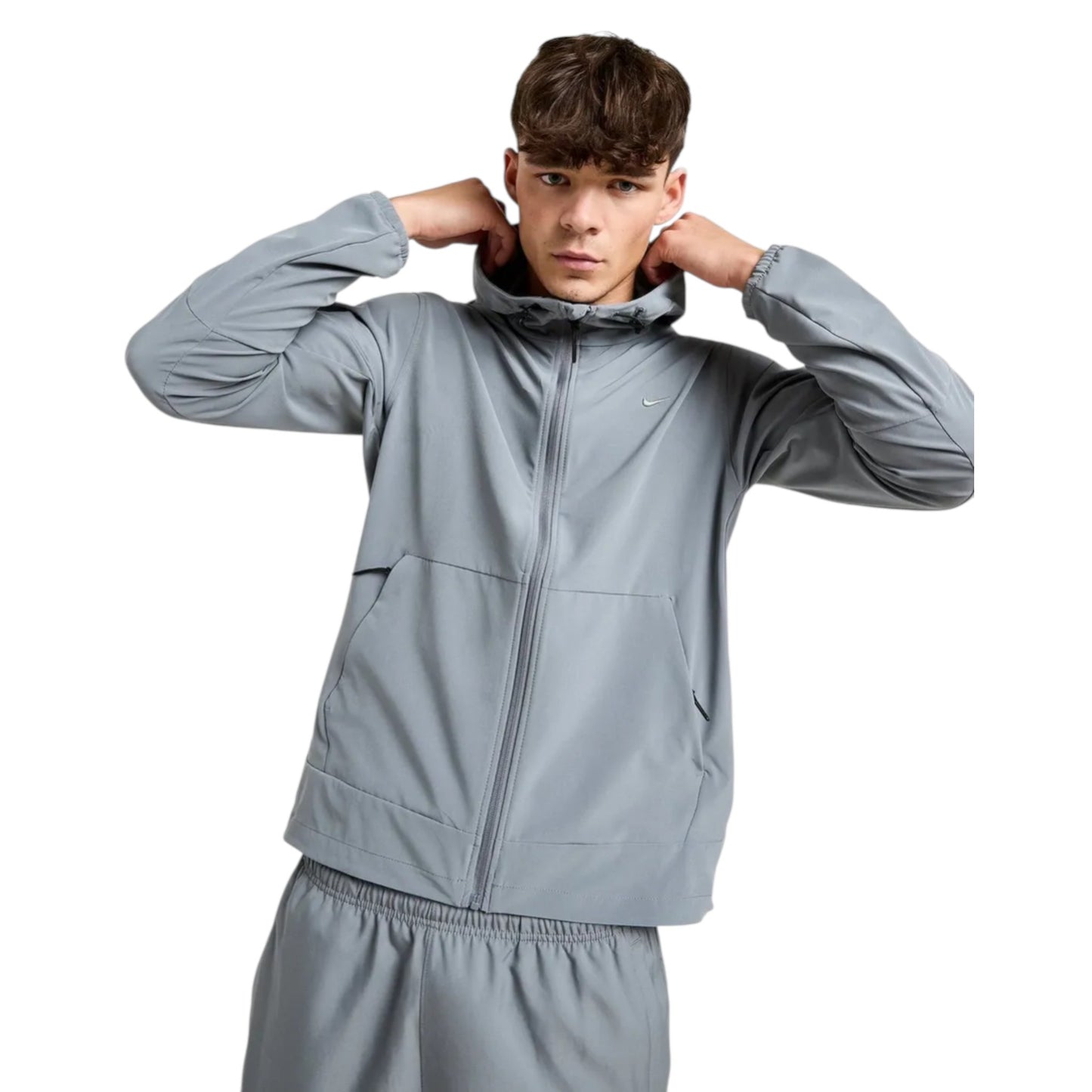Person wearing a gray tracksuit on a white background