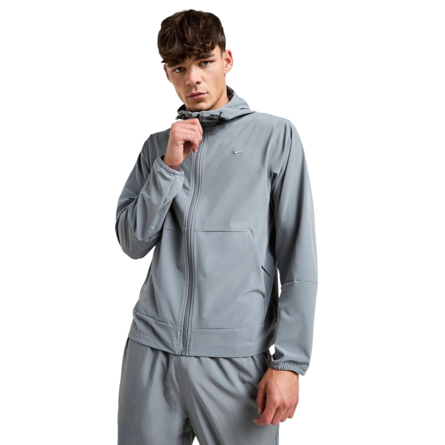 Man wearing a gray tracksuit on a white background
