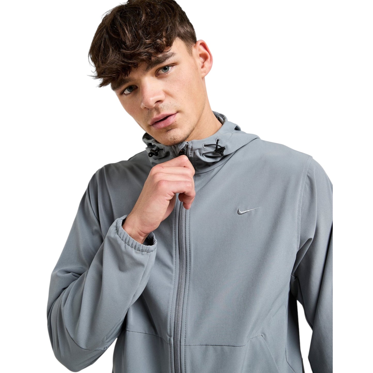 Man wearing a gray Nike jacket on a white background