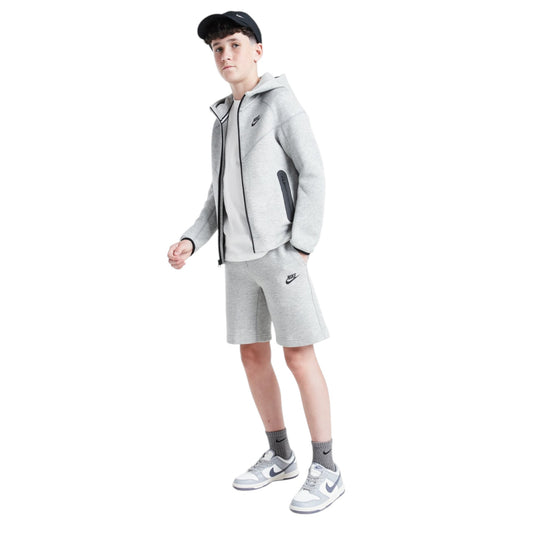 Person wearing a gray Nike tracksuit on a white background