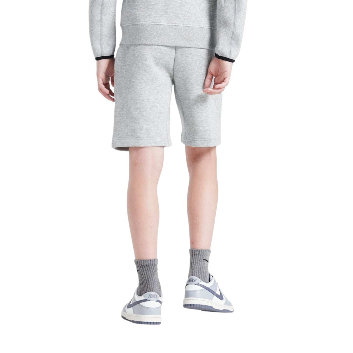 Person wearing a gray tracksuit with shorts on a white background