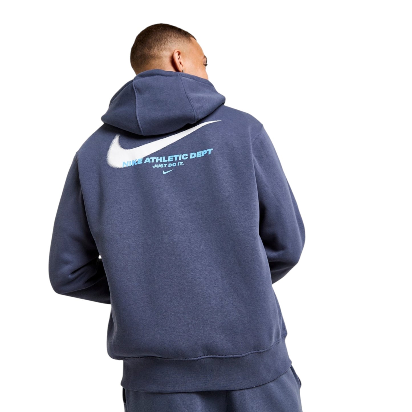 Person wearing a navy blue Nike hoodie with a logo on the back against a white background