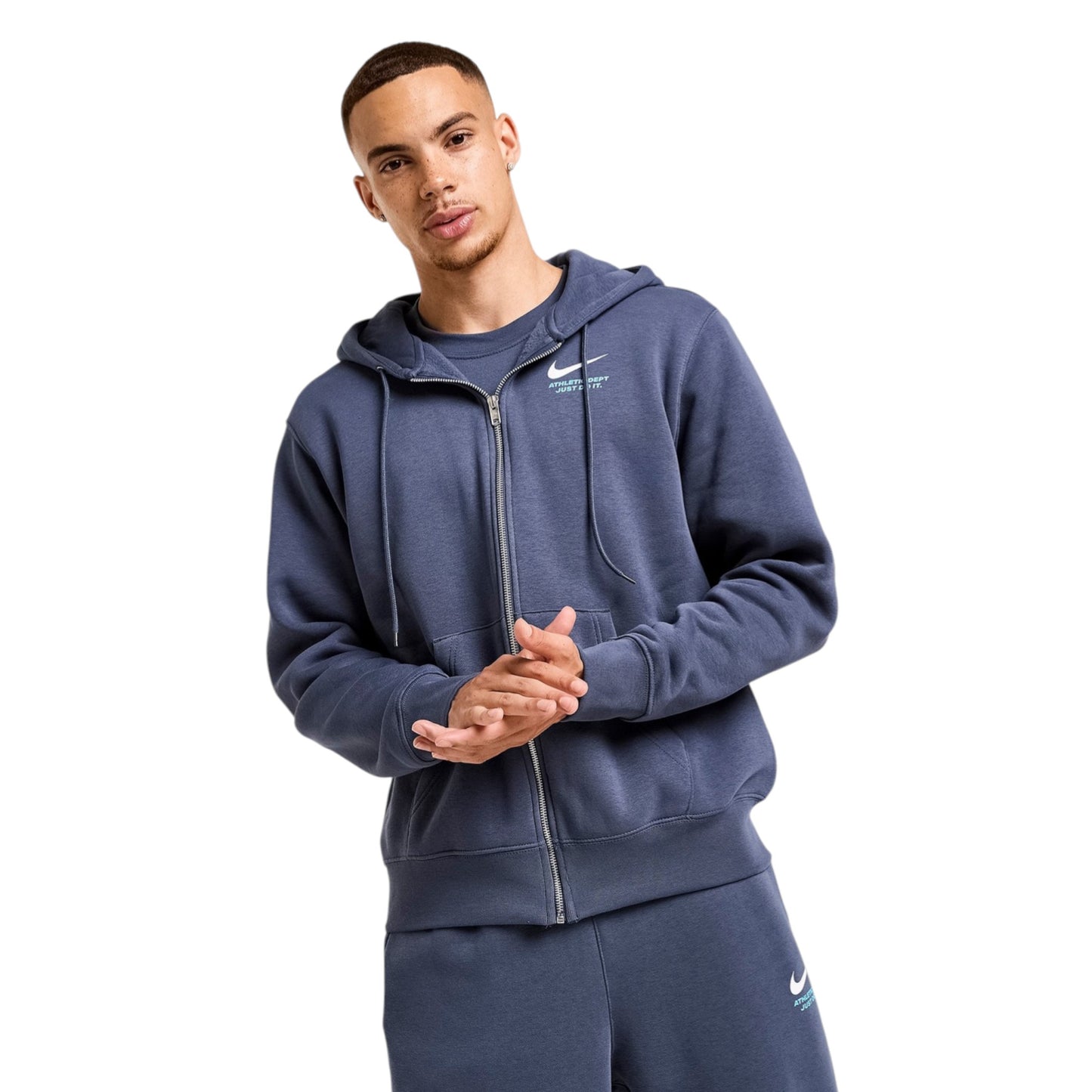 Man wearing a blue Nike tracksuit on a white background