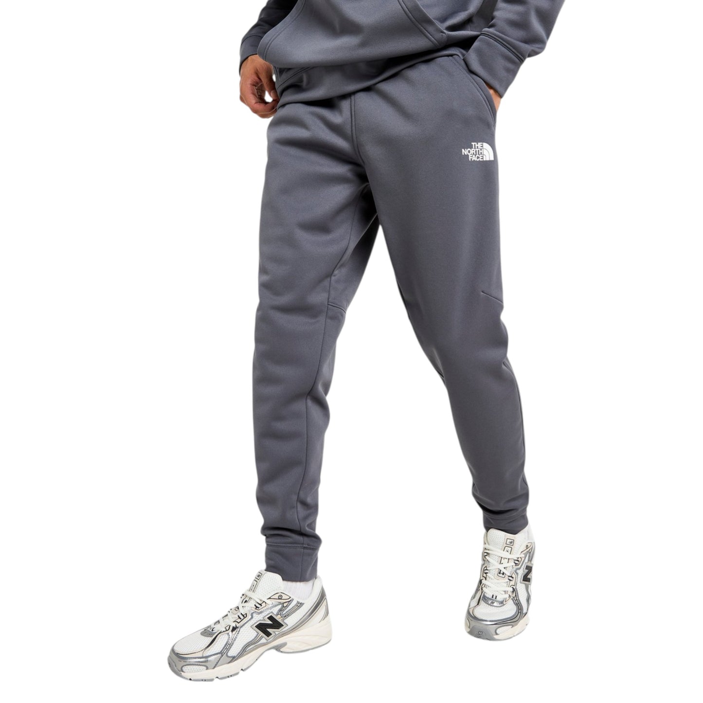Person wearing gray sweatpants with a brand logo on a white background