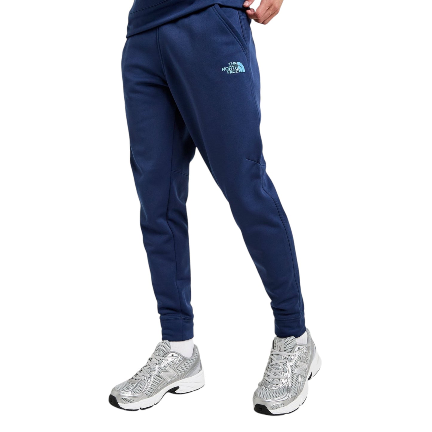 Blue jogger pants with a brand logo worn by a person on a white background