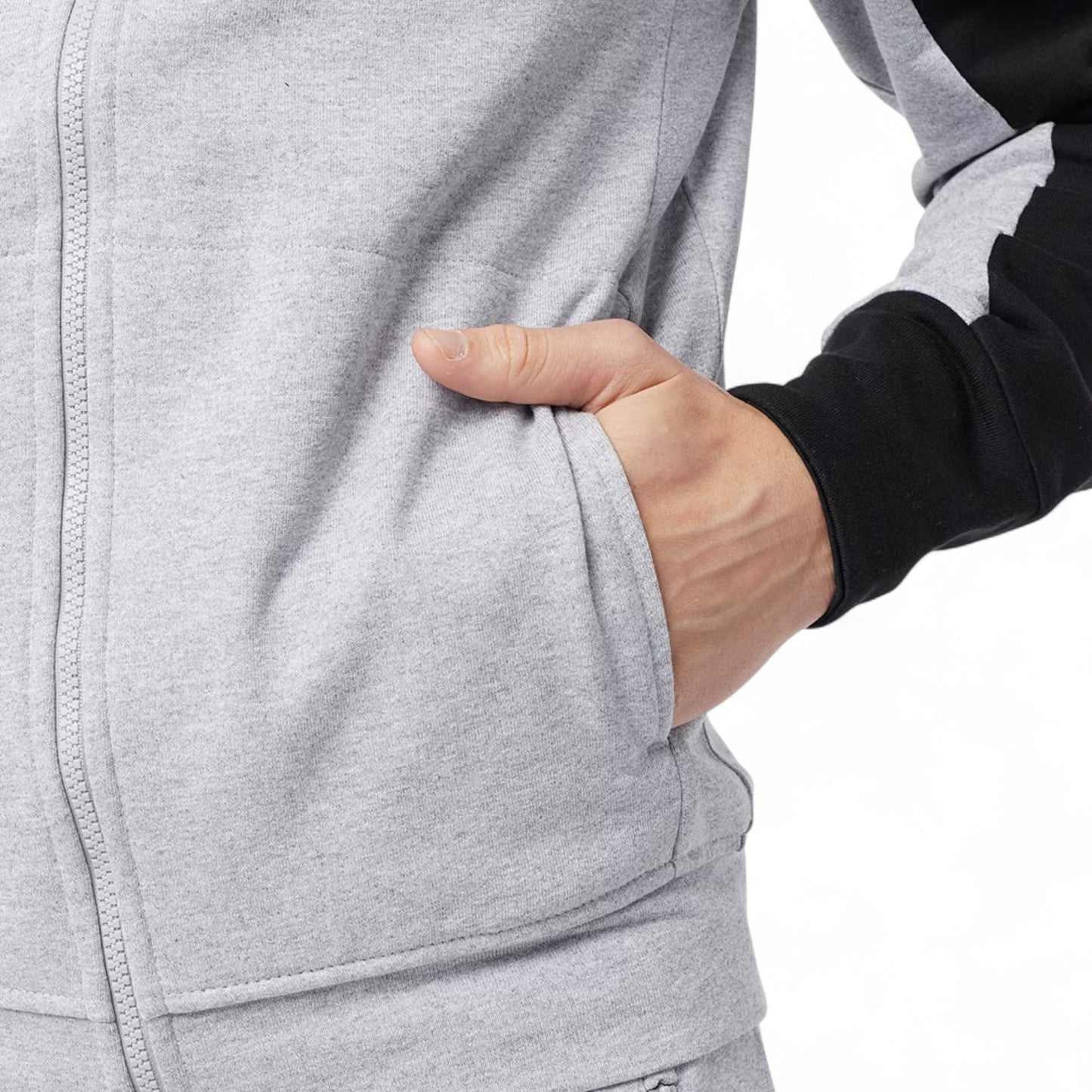 Person wearing a gray hoodie with a hand in the pocket on a white background