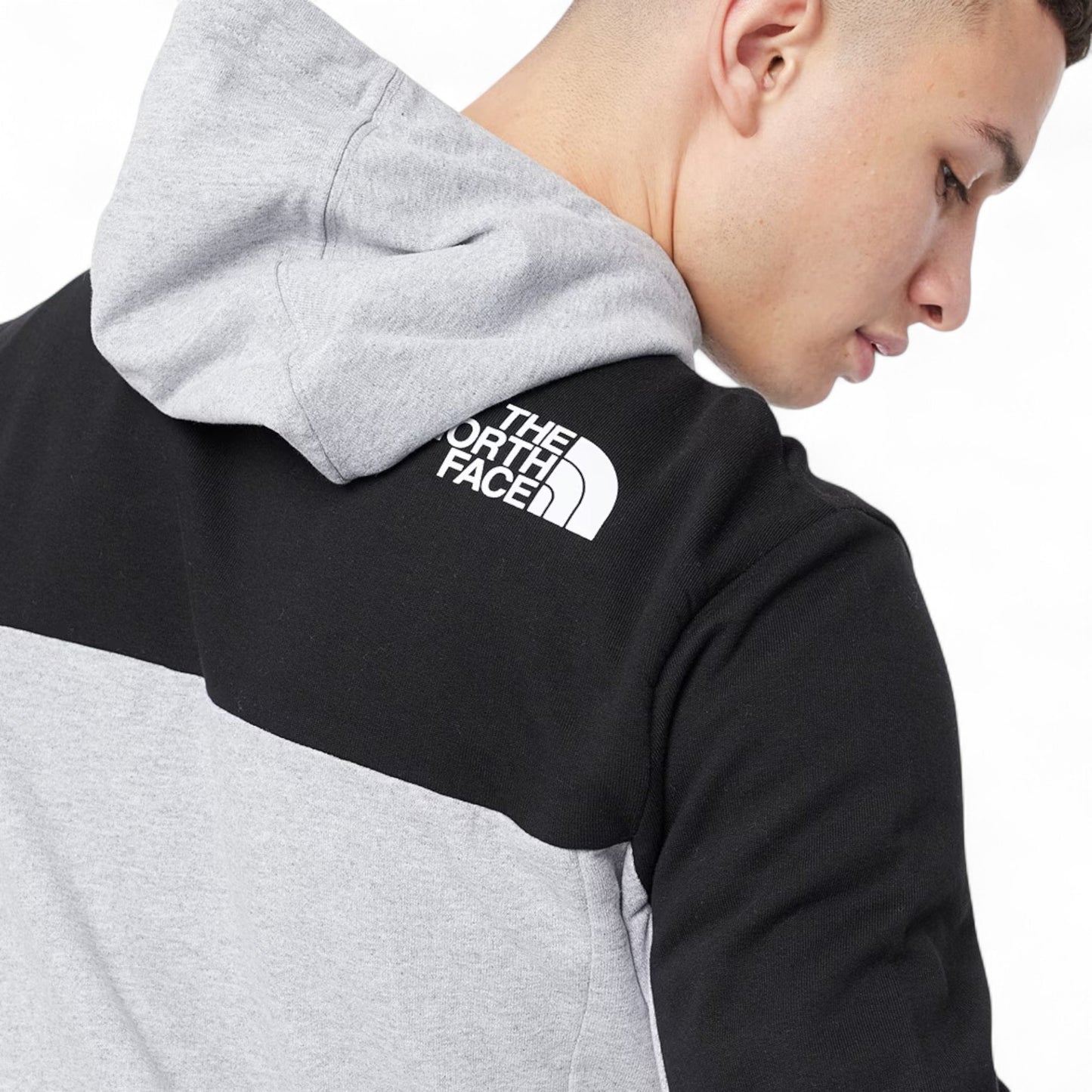 Person wearing a black and gray hoodie with The North Face logo.