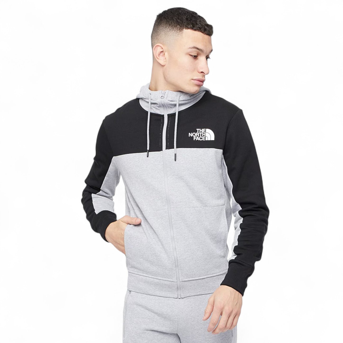 Person wearing a black and gray hoodie with 'The North Face' logo on a white background