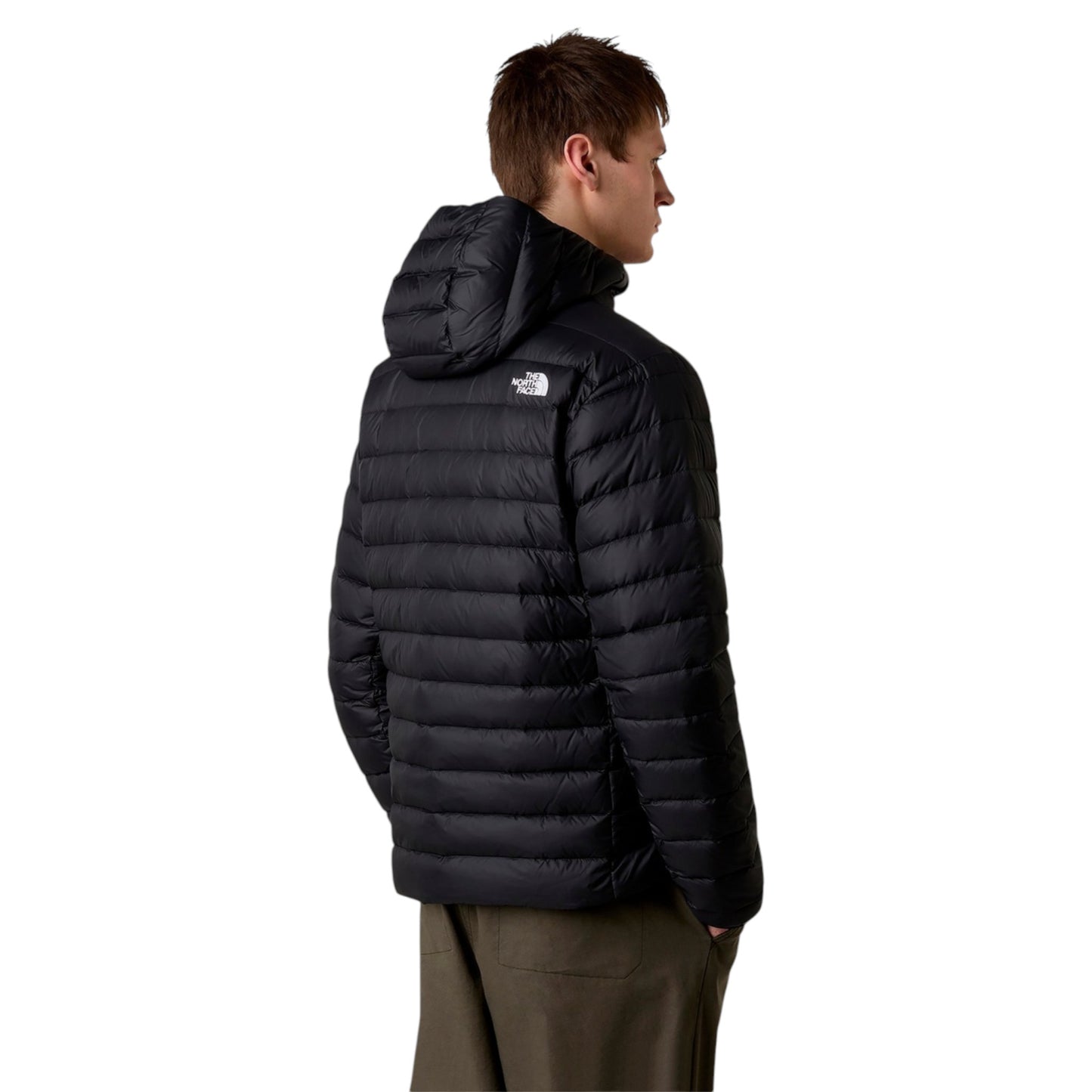 Person wearing a black puffer jacket with a brand logo on a white background