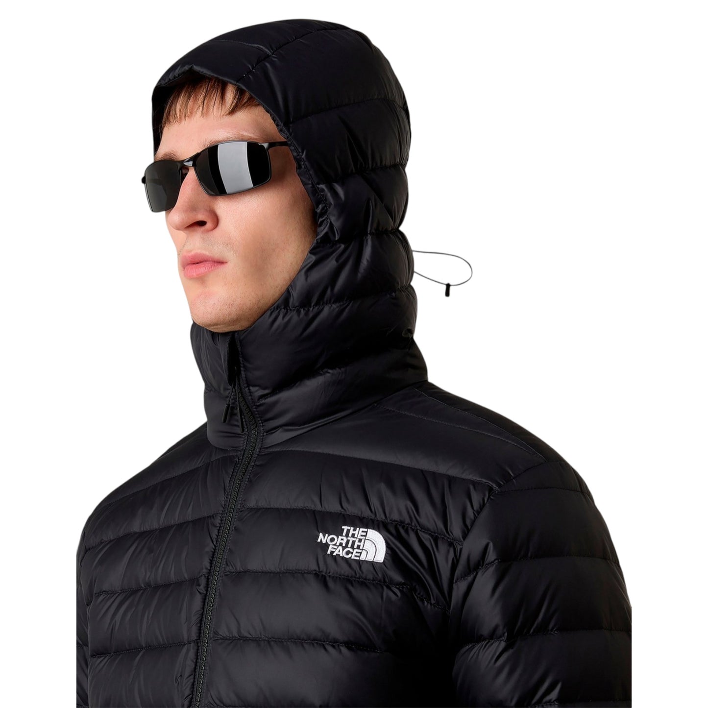 Person wearing a black puffer jacket with a hood and sunglasses, featuring The North Face logo.