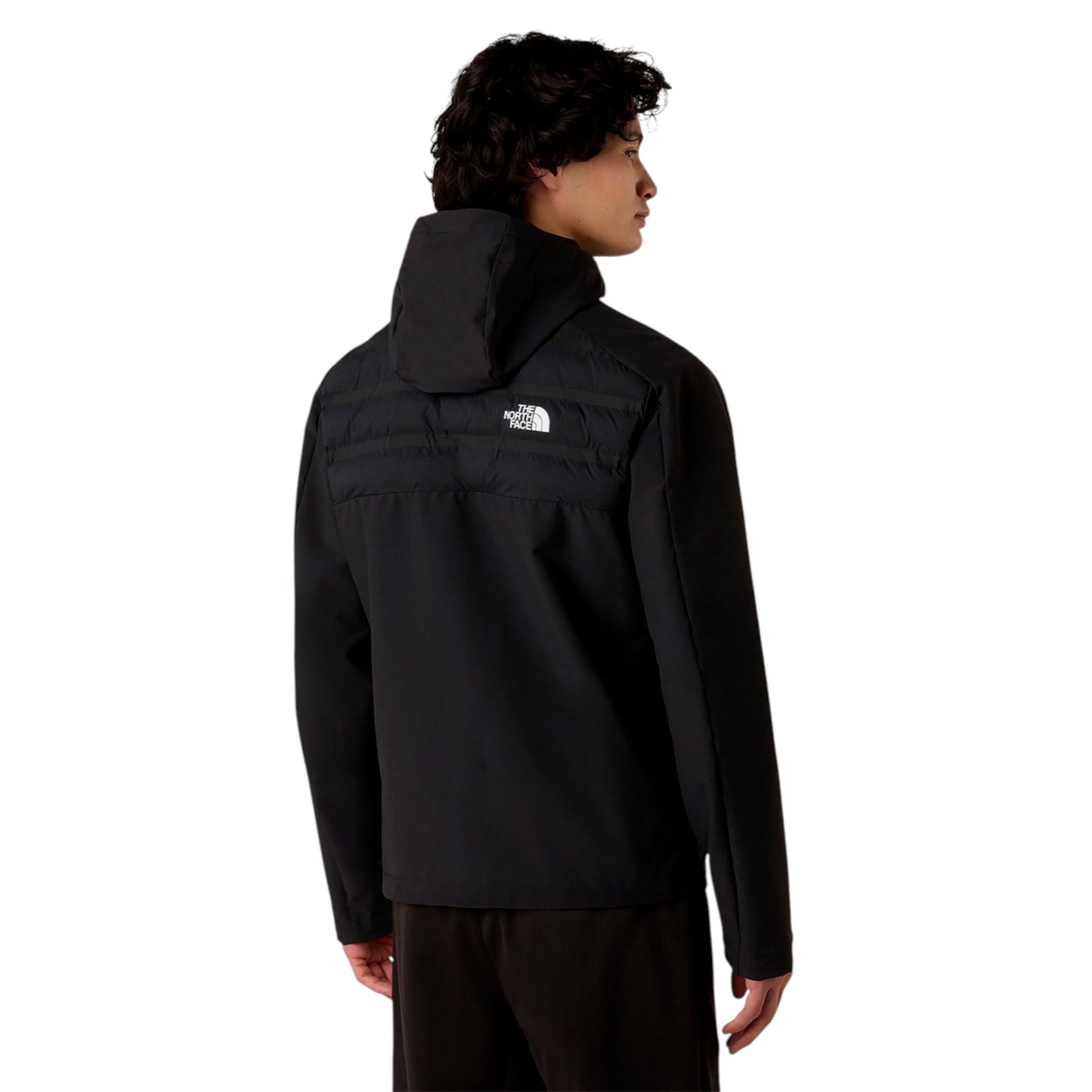 Person wearing a black jacket with a brand logo on the back against a white background