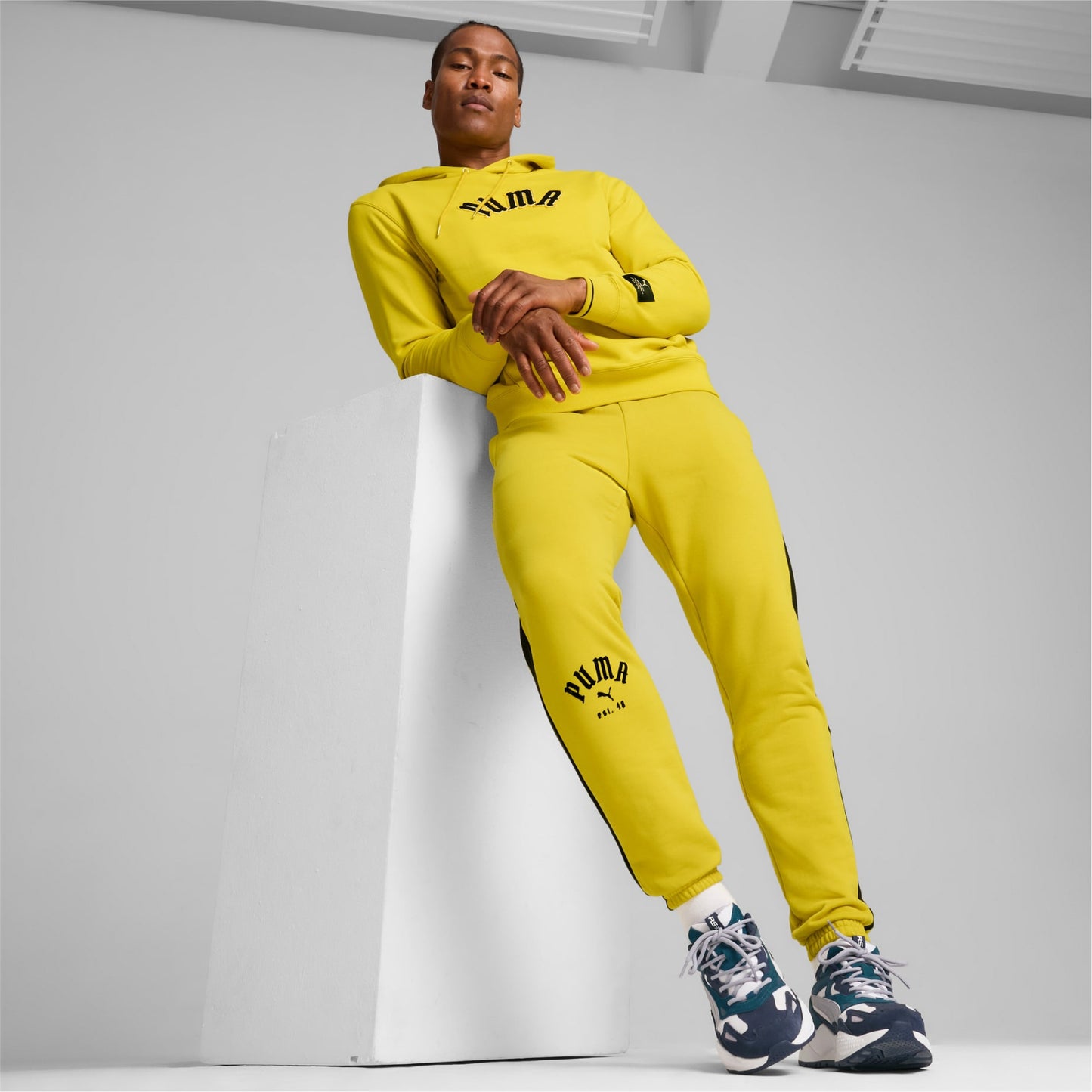 Person wearing a yellow Puma tracksuit against a plain background