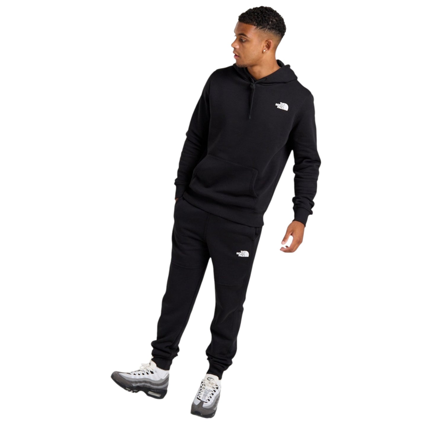 Person wearing a black tracksuit with a logo on a white background