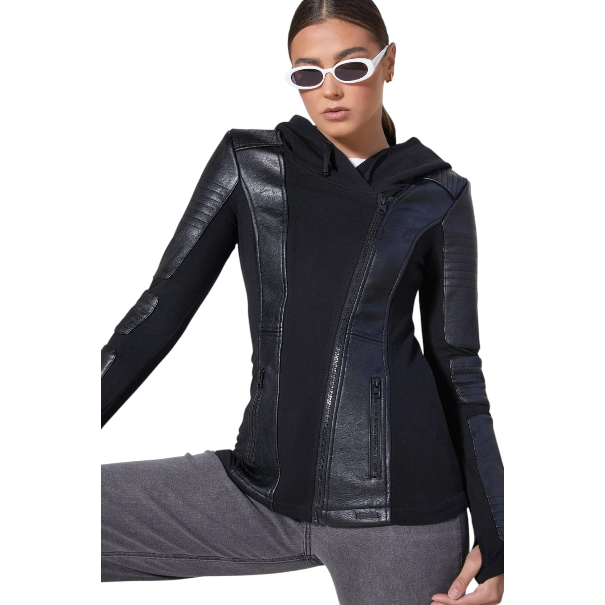 Person wearing a black leather jacket with gray pants on a white background