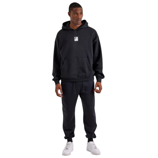 Man wearing a black hoodie and pants set on a white background