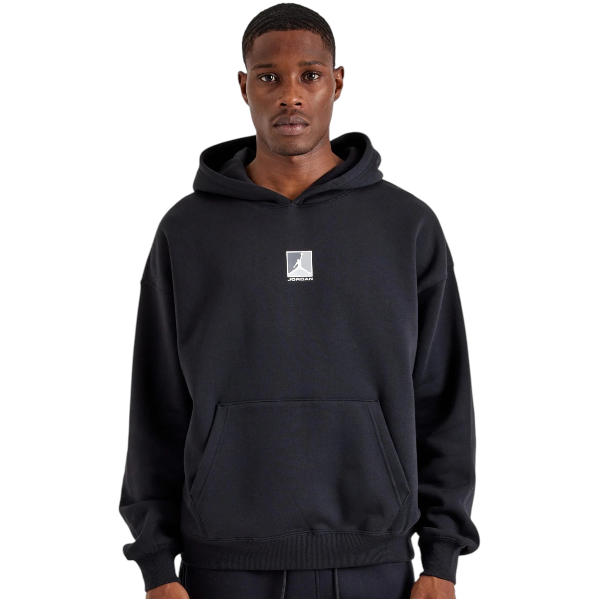 Man wearing a black hoodie with a small logo on a white background