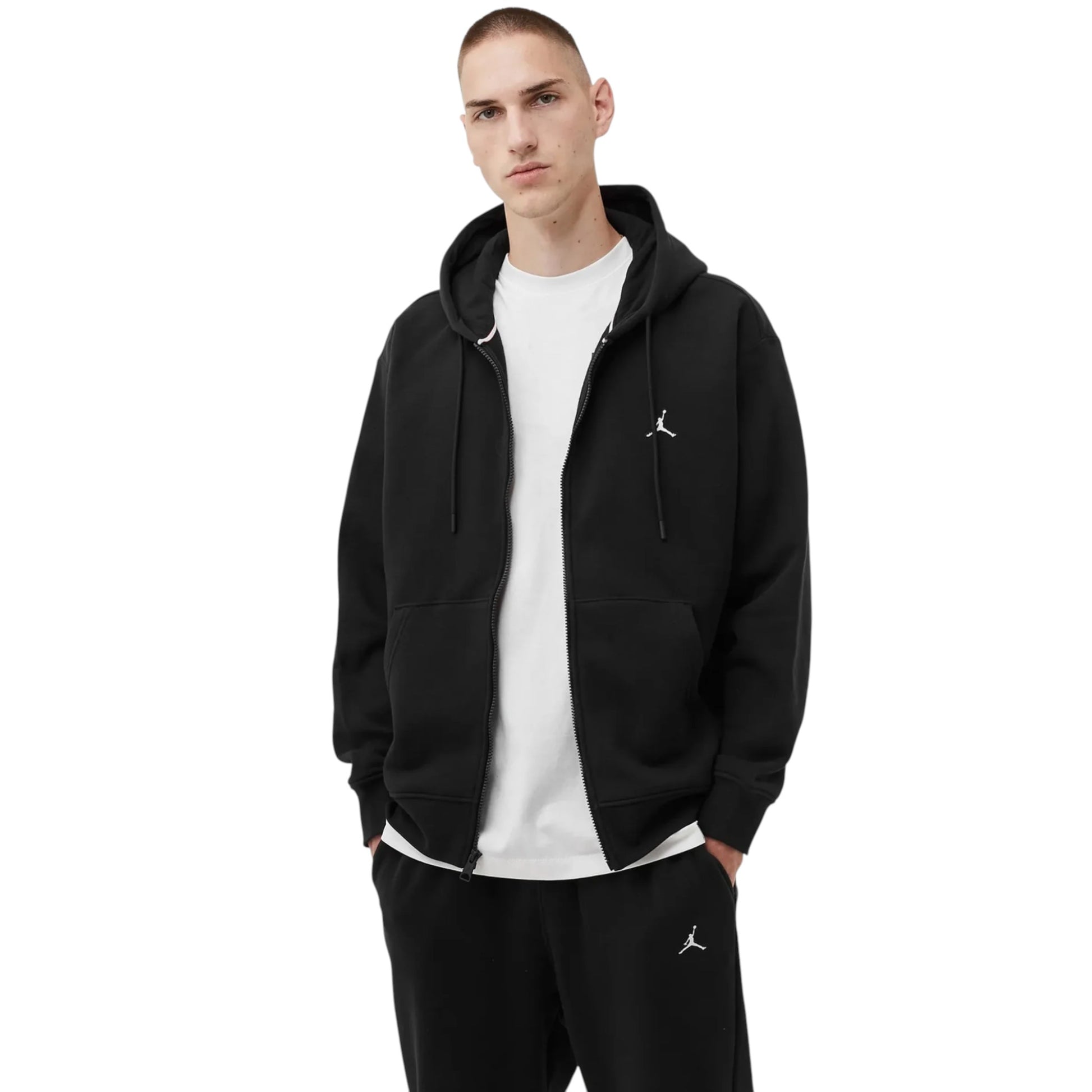 Man wearing a black hoodie and pants with a logo on a white background