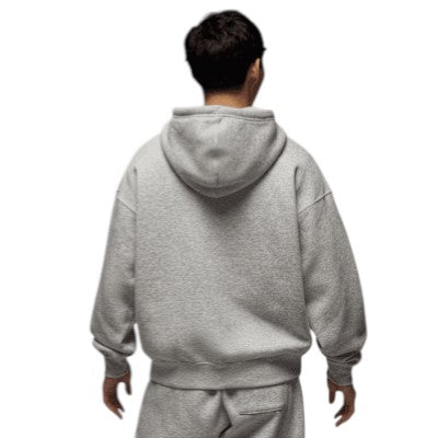 Person wearing a gray hoodie and pants on a white background