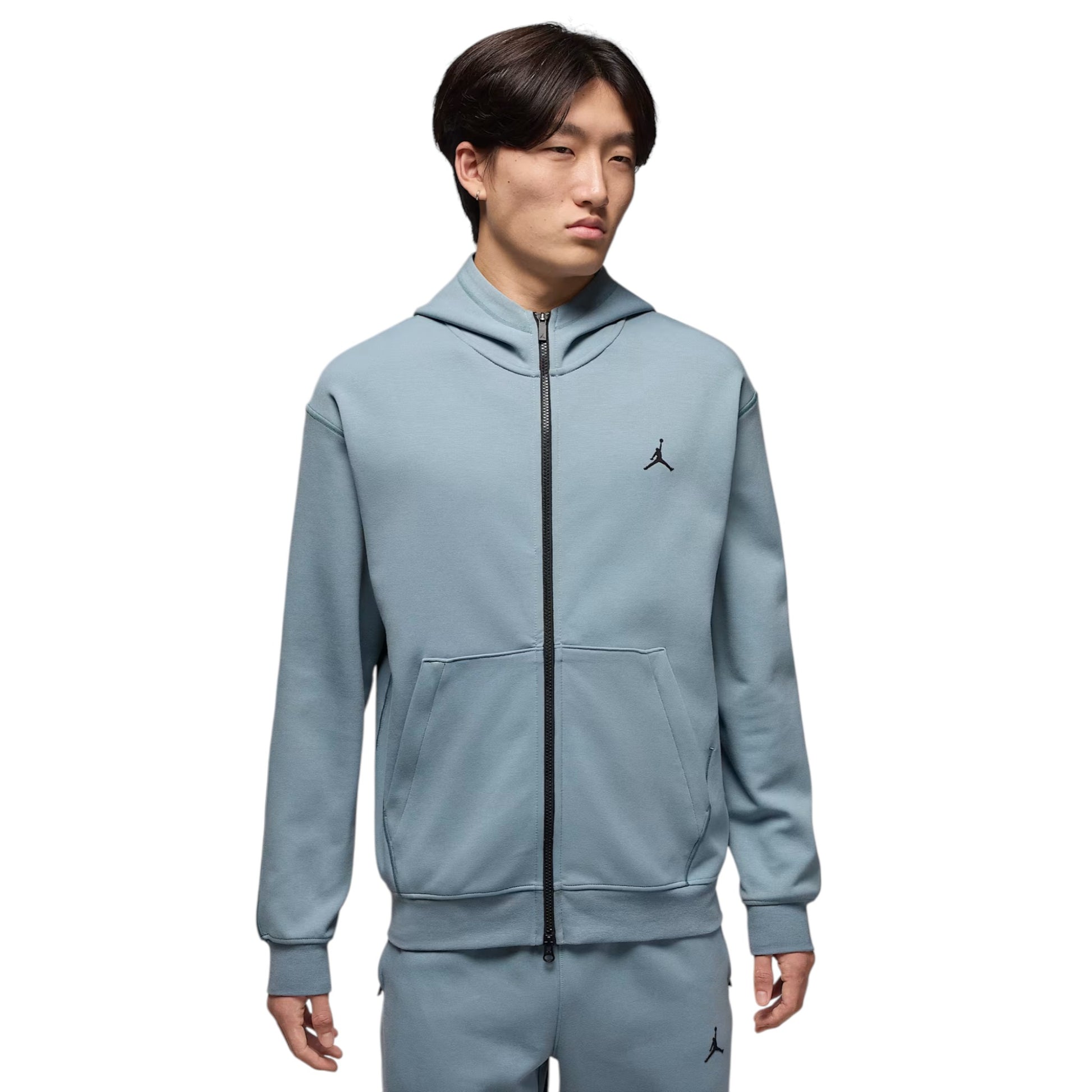 Person wearing a light blue hoodie with a brand logo on a white background