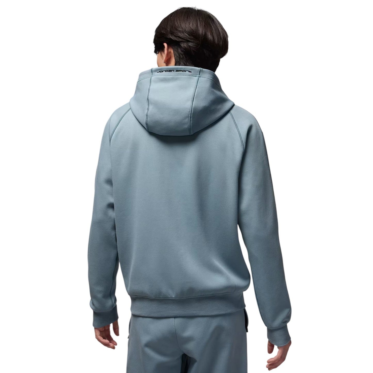 Person wearing a light blue tracksuit on a white background