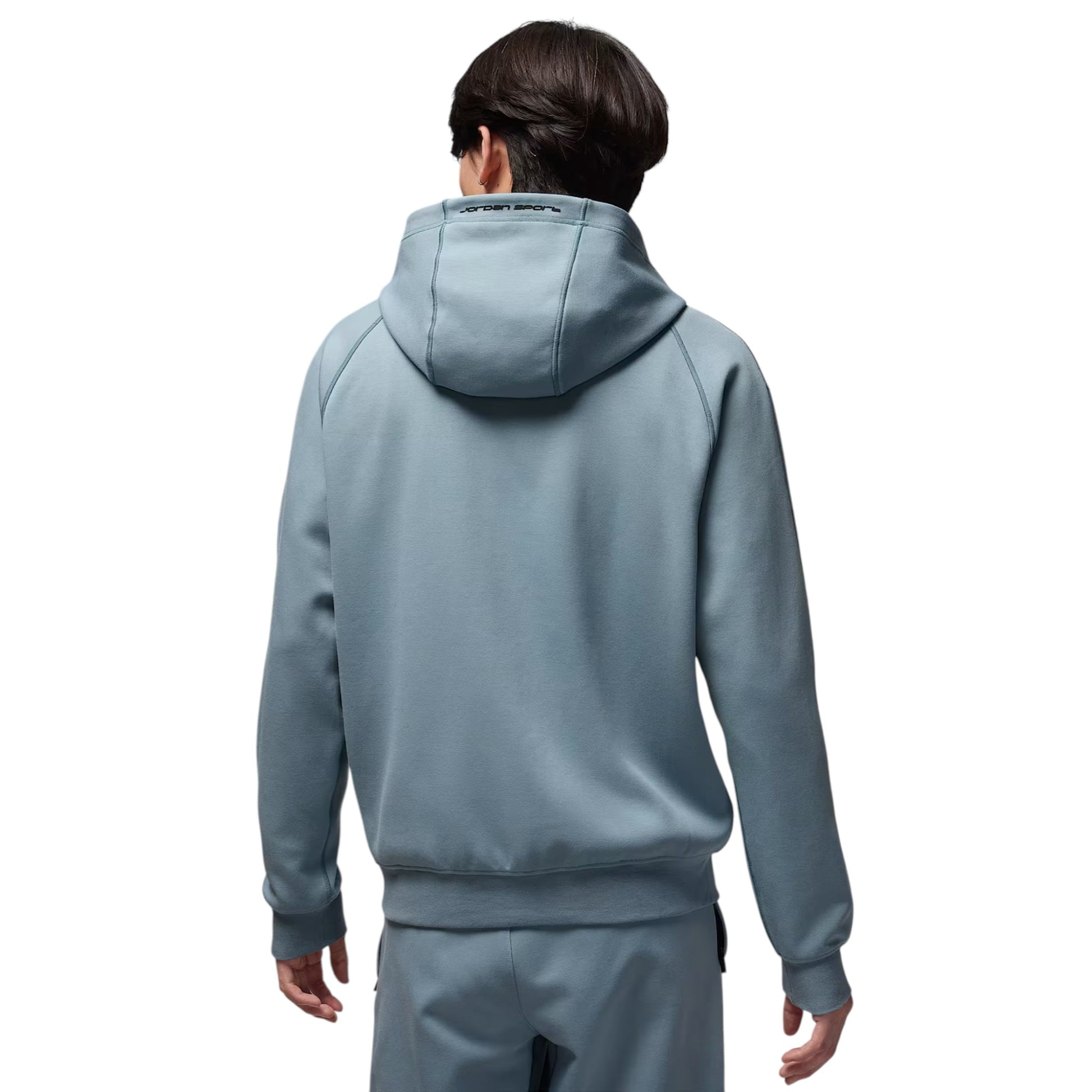 Person wearing a light blue tracksuit on a white background