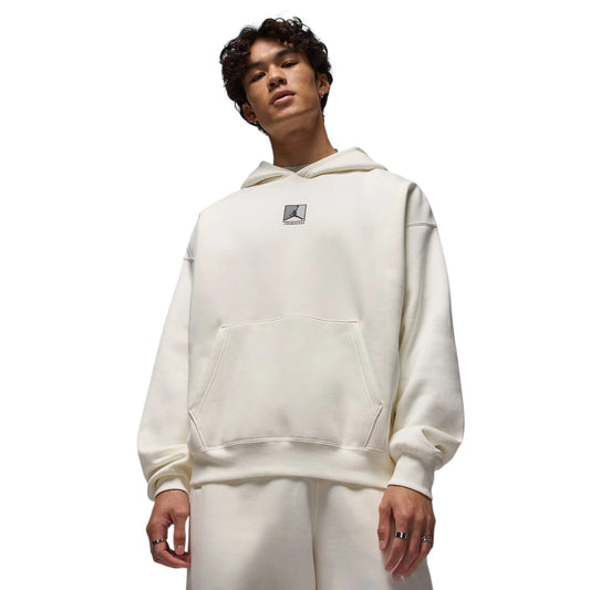 Person wearing a white hoodie with a small logo on a white background