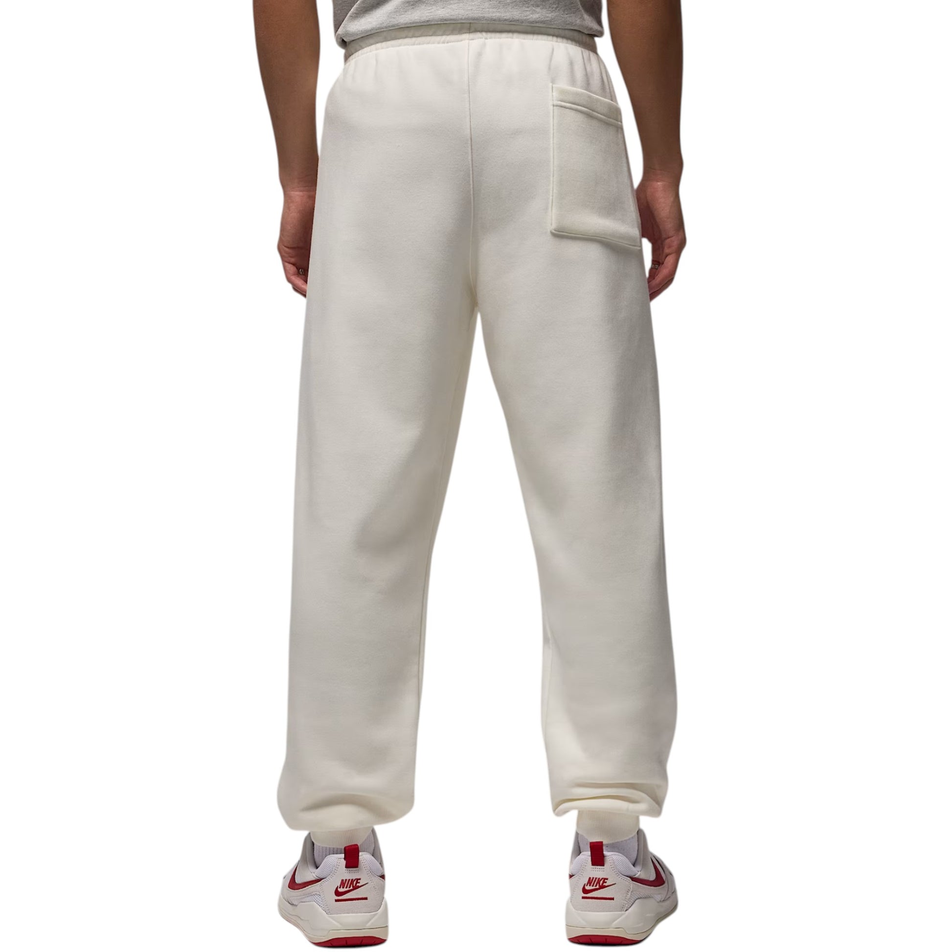 White sweatpants worn by a person on a white background