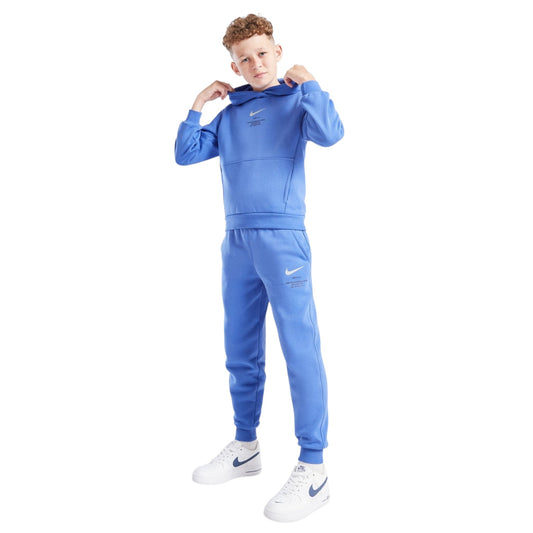 Child wearing a blue Nike tracksuit on a white background