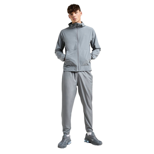 Person wearing a gray tracksuit on a white background