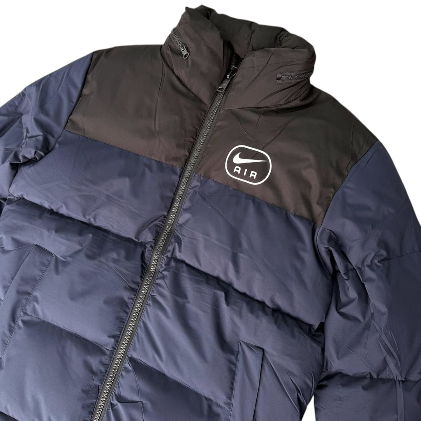 Two-tone puffer jacket with Nike logo on a white background