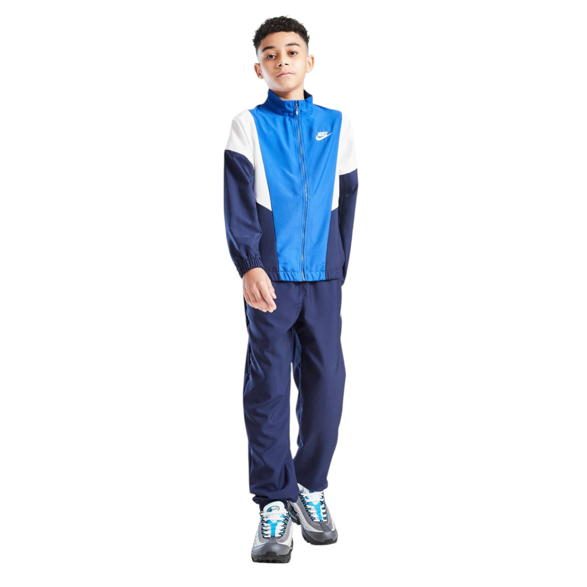 Child wearing a blue and white tracksuit with Nike logo on a white background