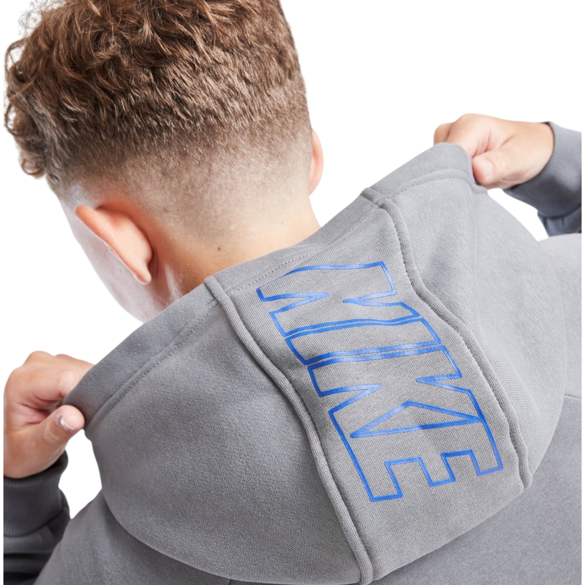 Person wearing a gray Nike hoodie with blue text on a white background