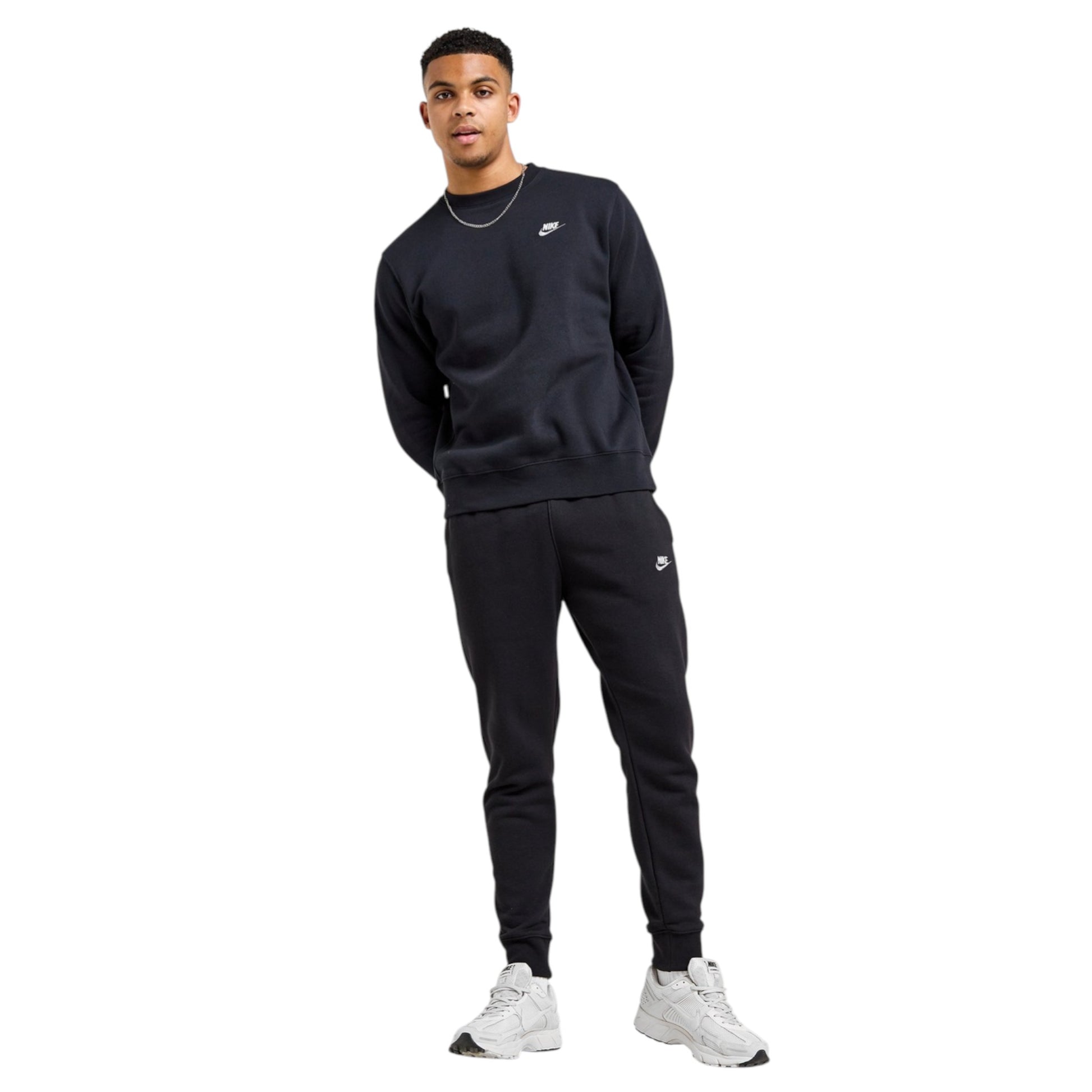 Person wearing a black Nike tracksuit on a white background