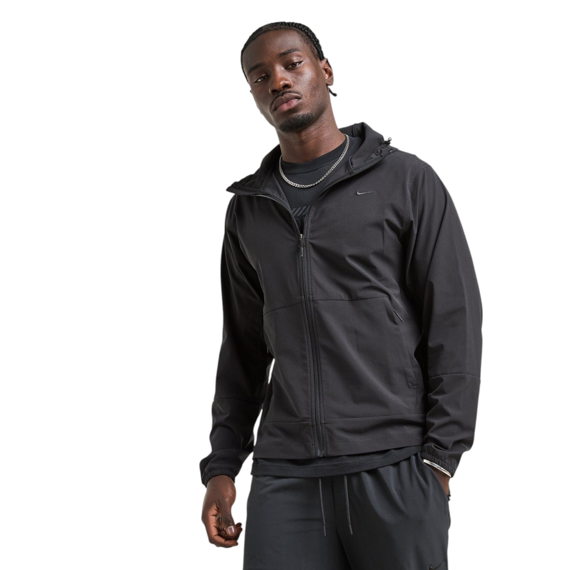 Man wearing a black jacket and pants on a white background