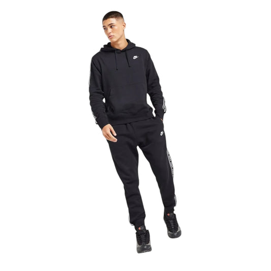 Person wearing a black Nike tracksuit on a white background