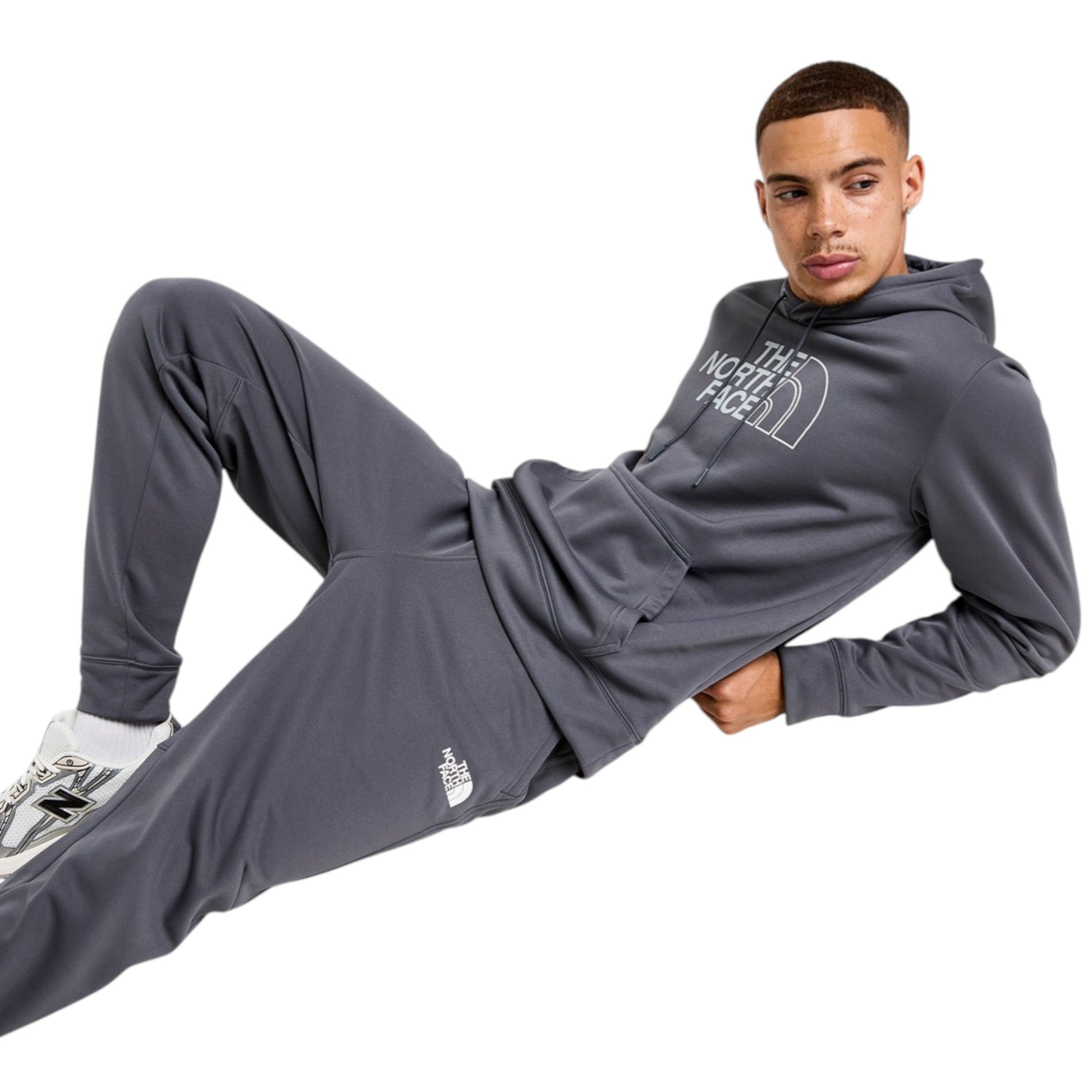 Person wearing a gray 'The North Face' hoodie and pants on a white background