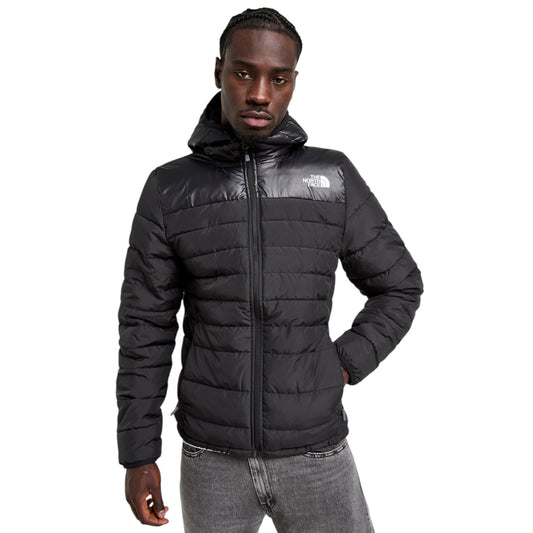 Person wearing a black puffer jacket with a brand logo on a white background