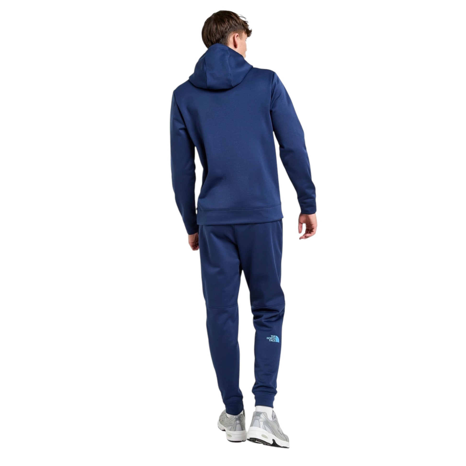 Person wearing a blue tracksuit with a brand logo on a white background