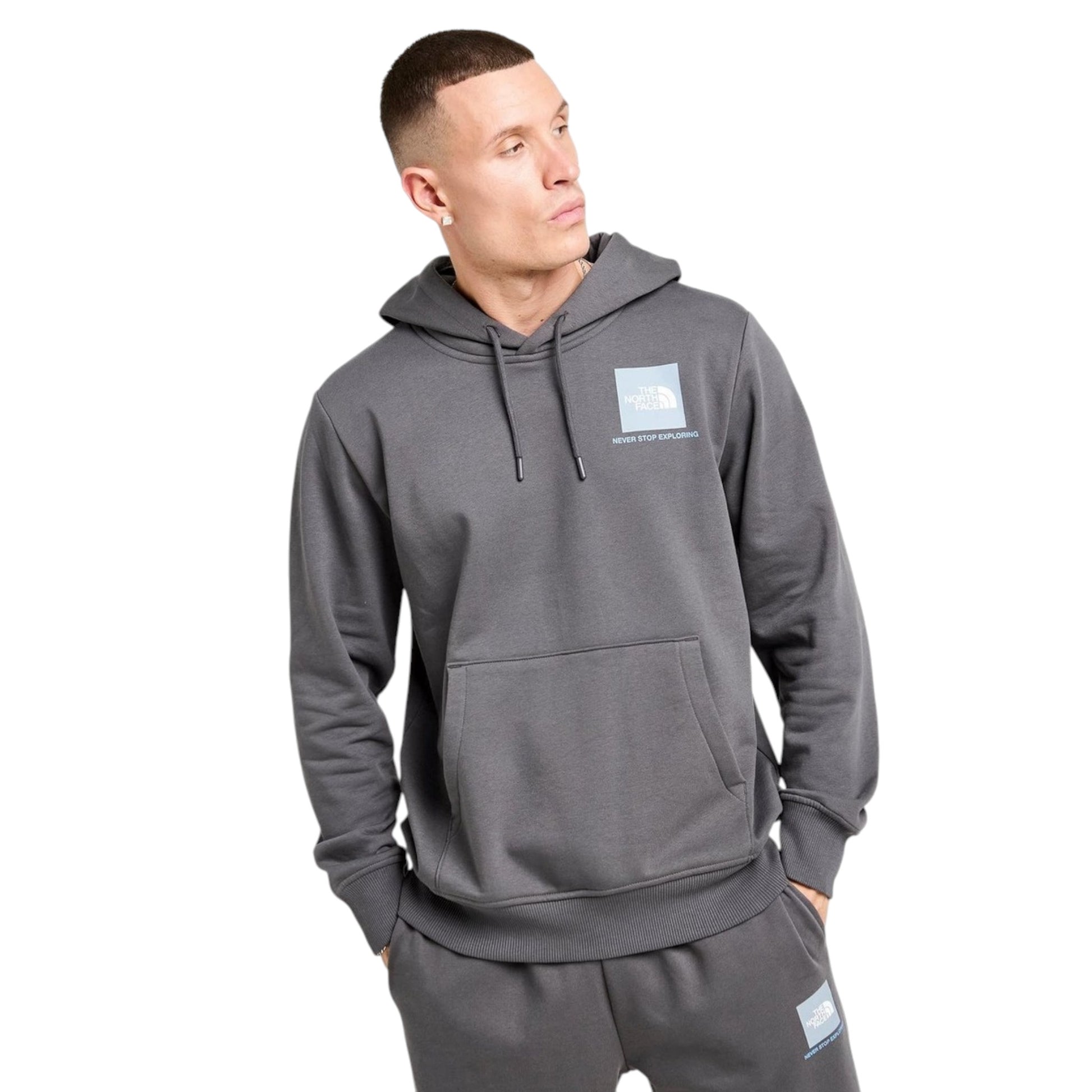Man wearing a gray hoodie with a logo on a white background