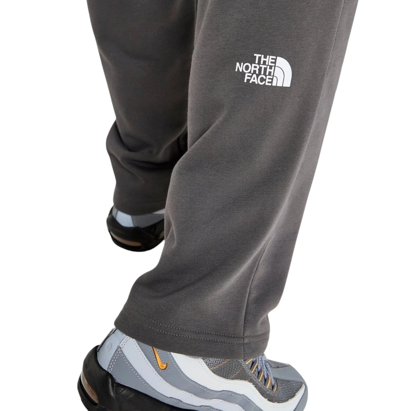 Gray sweatpants with The North Face logo worn by a person on a white background
