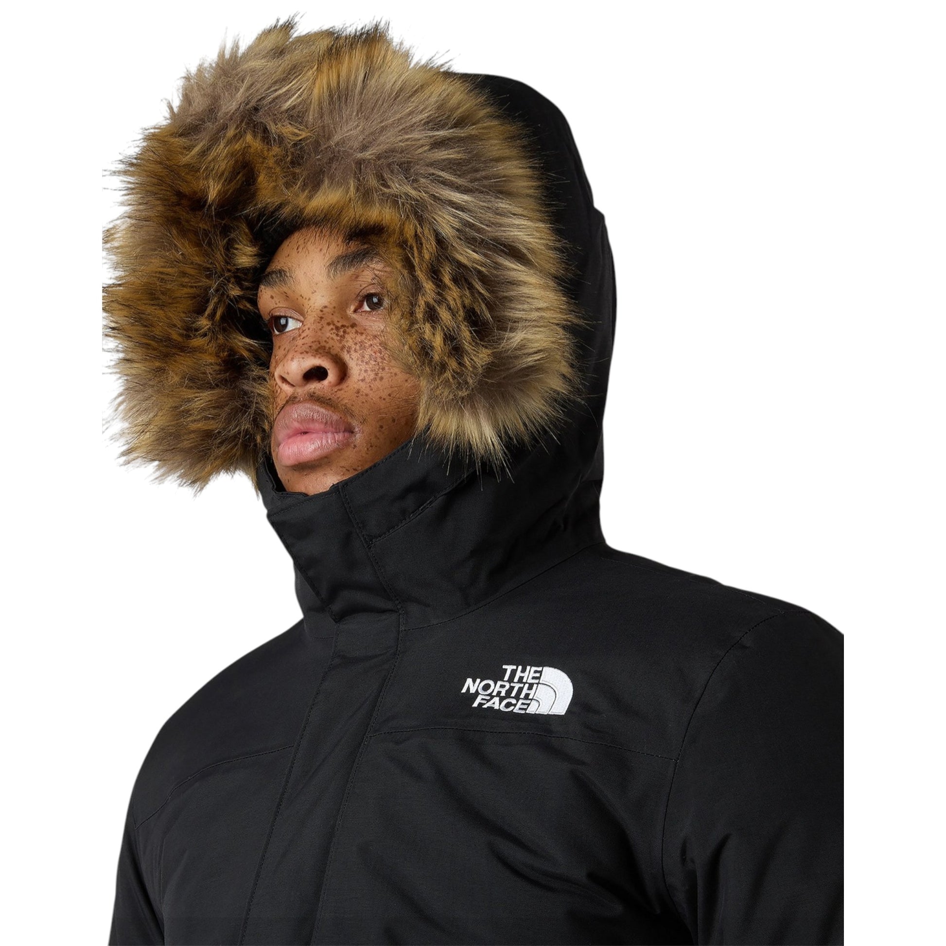 Person wearing a black winter jacket with a fur-lined hood on a white background, featuring The North Face logo.