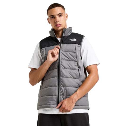 Man wearing a gray and black North Face vest on a white background