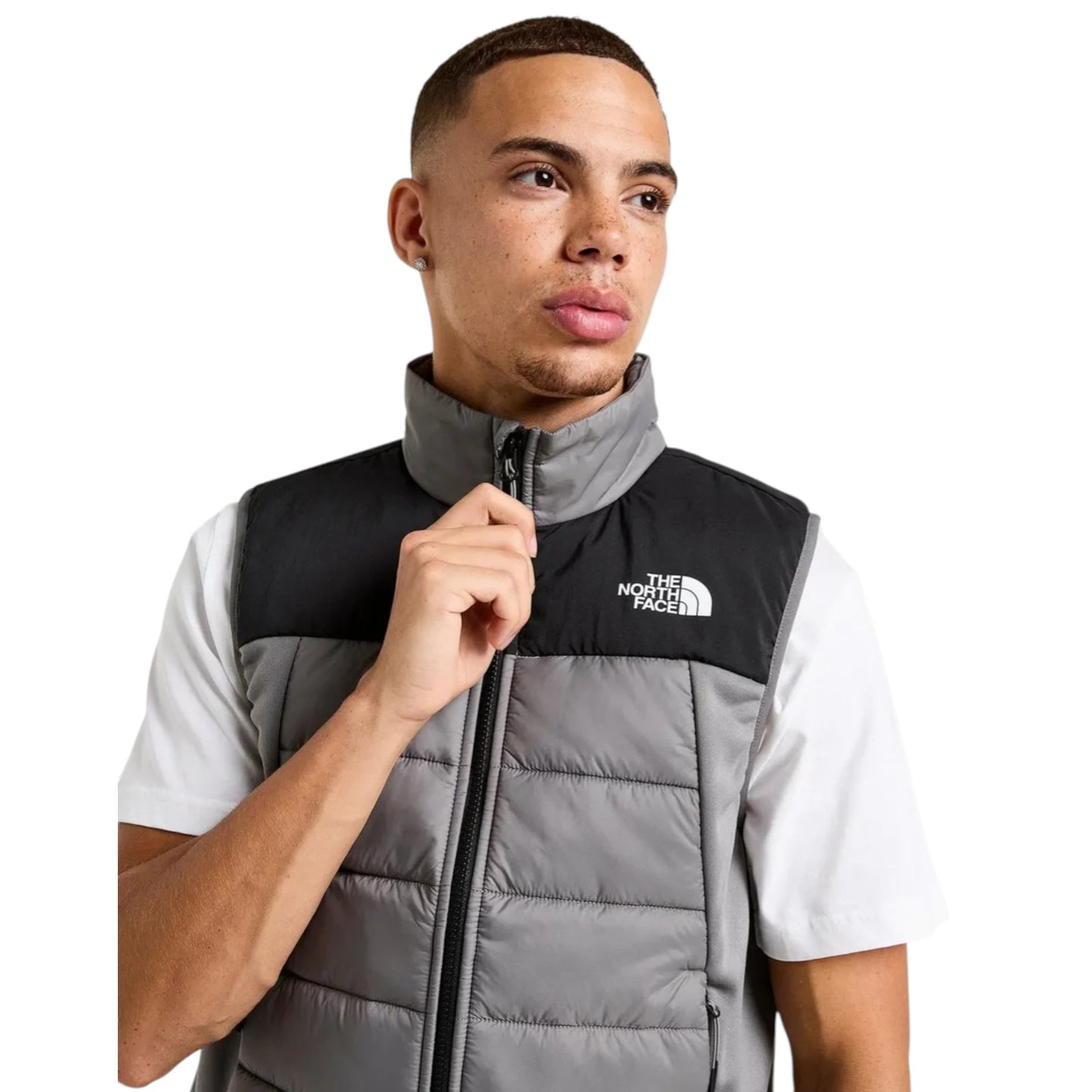 Man wearing a gray and black North Face vest on a white background