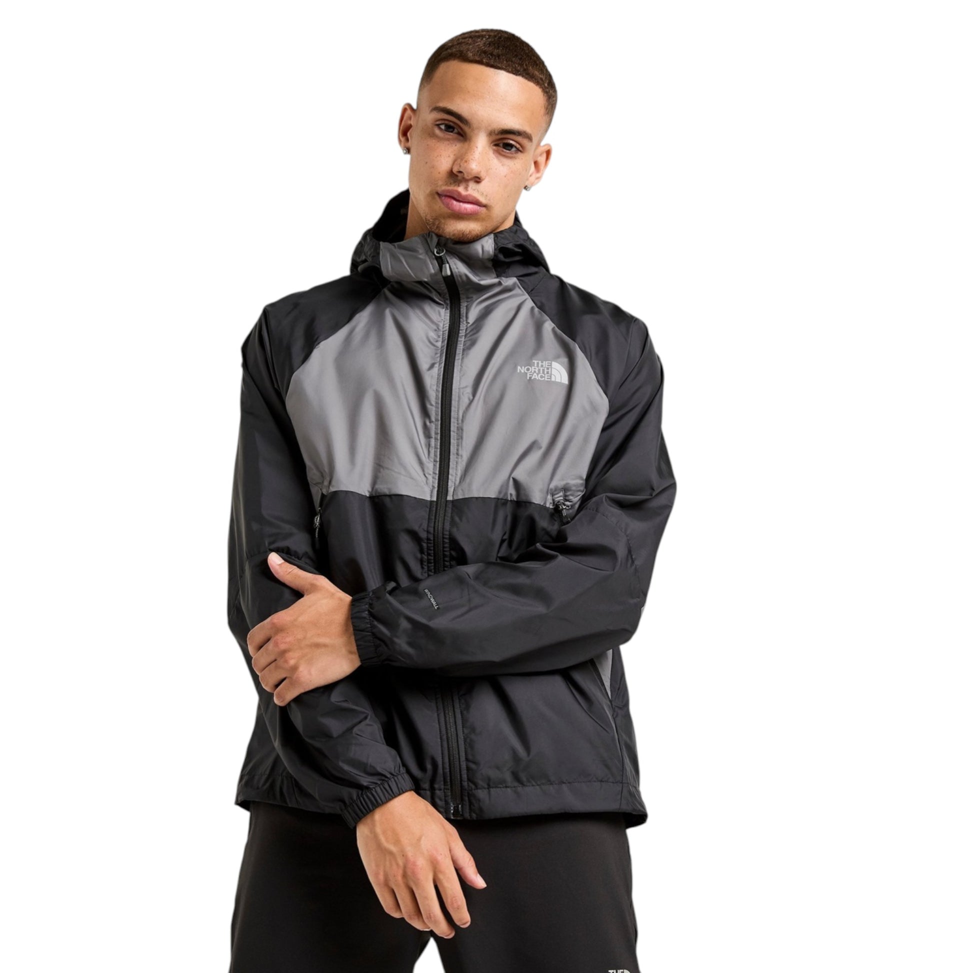 Person wearing a black and gray jacket with a brand logo on a white background