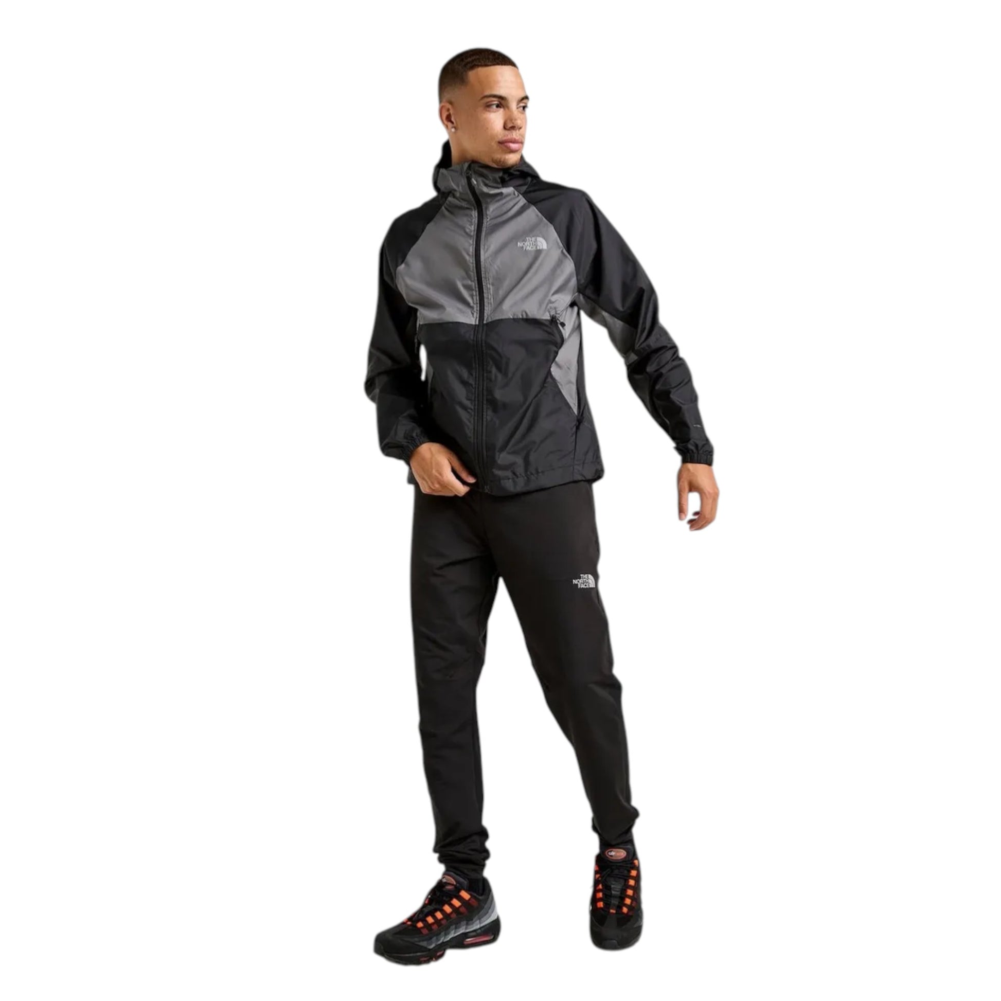 Person wearing a black and gray jacket with The North Face logo on a white background