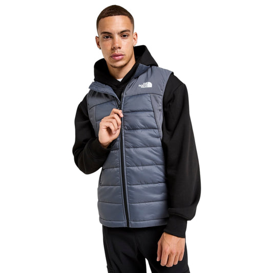 Man wearing a black and gray North Face vest on a white background