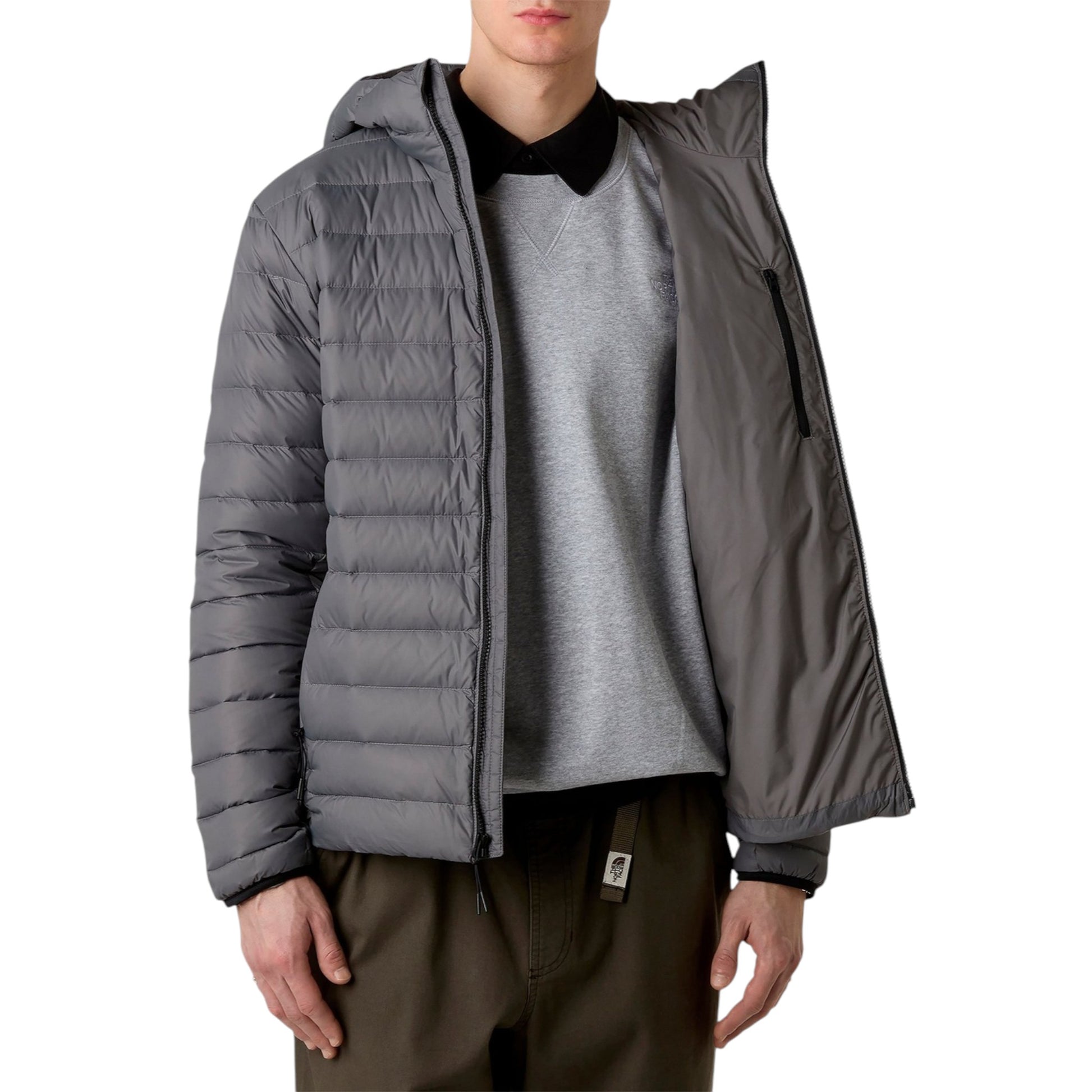Person wearing a gray puffer jacket over a gray shirt on a white background