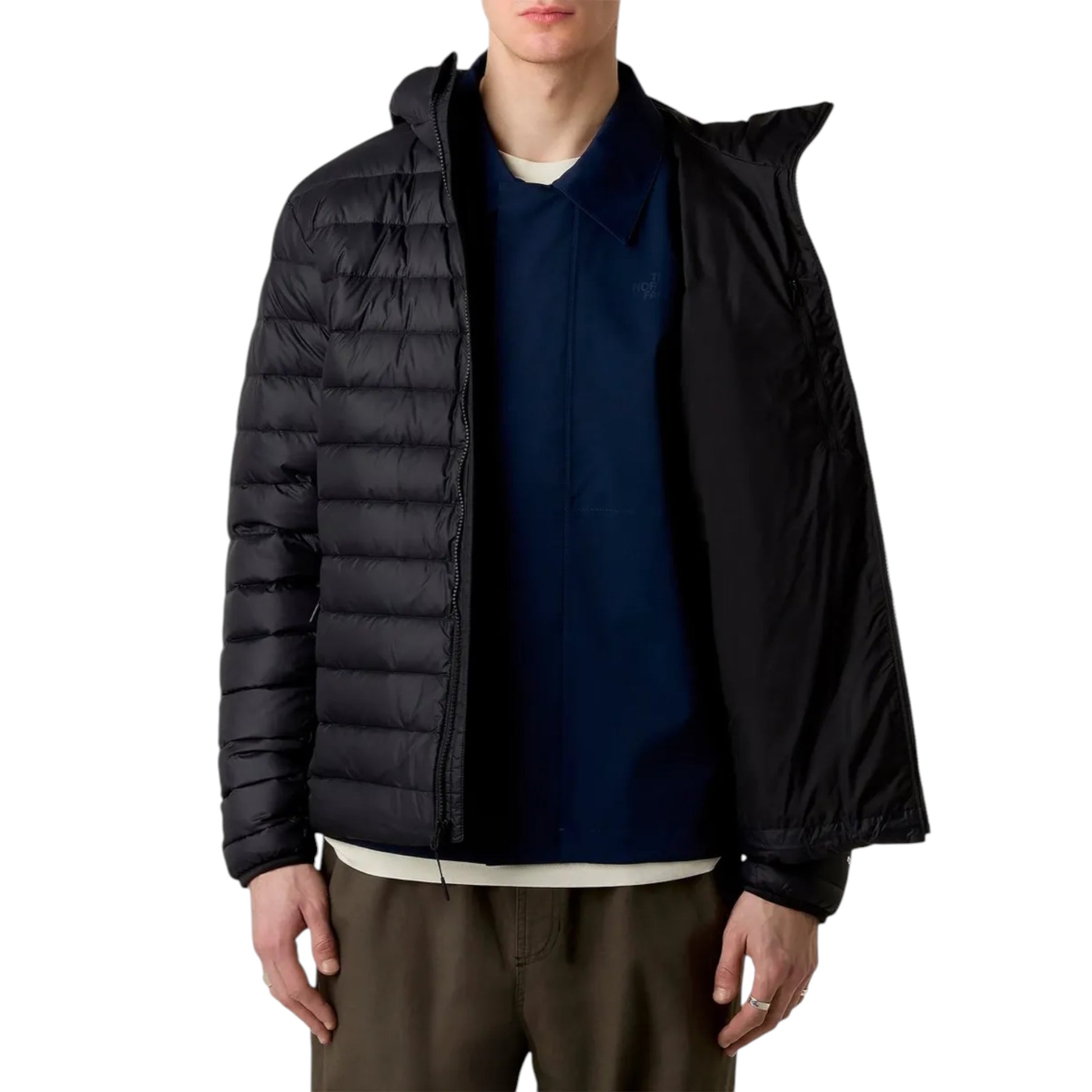 Person wearing a black puffer jacket over a blue shirt on a white background