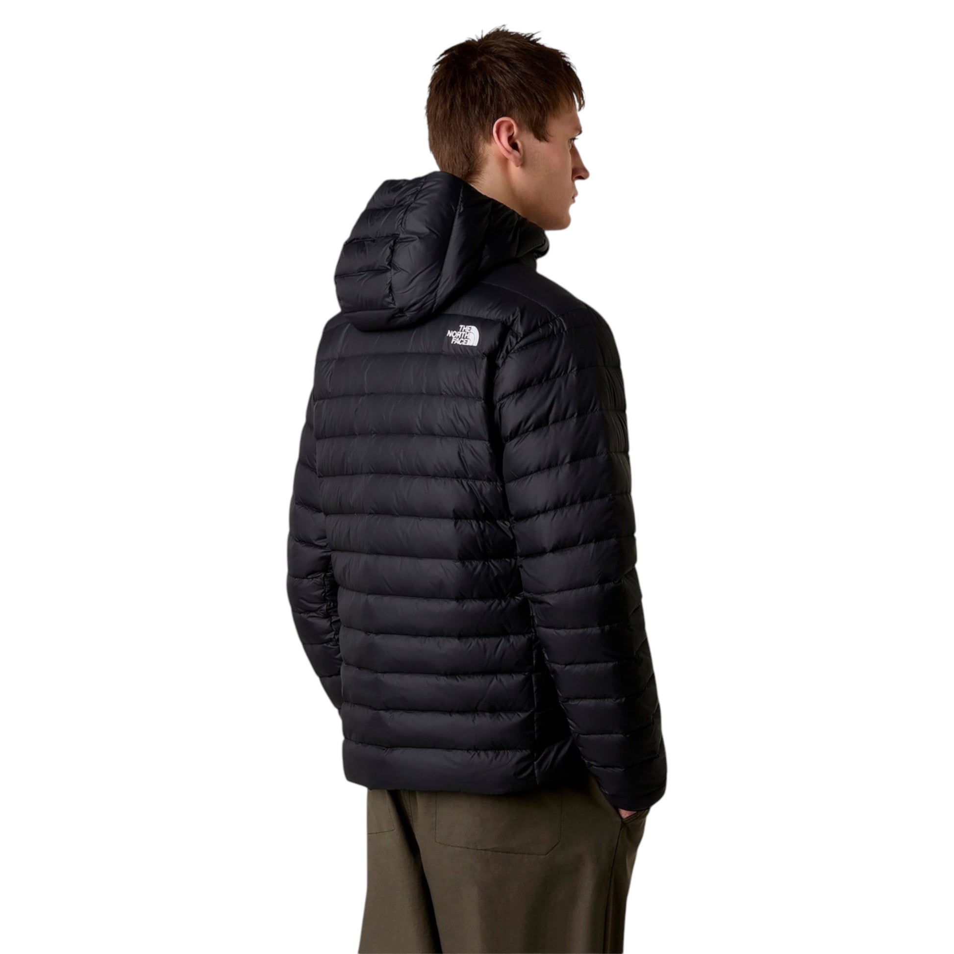 Person wearing a black puffer jacket with a brand logo on a white background