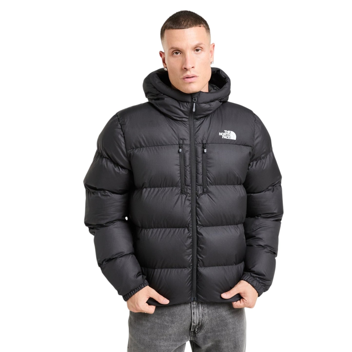 Man wearing a black puffer jacket with 'The North Face' logo on a white background